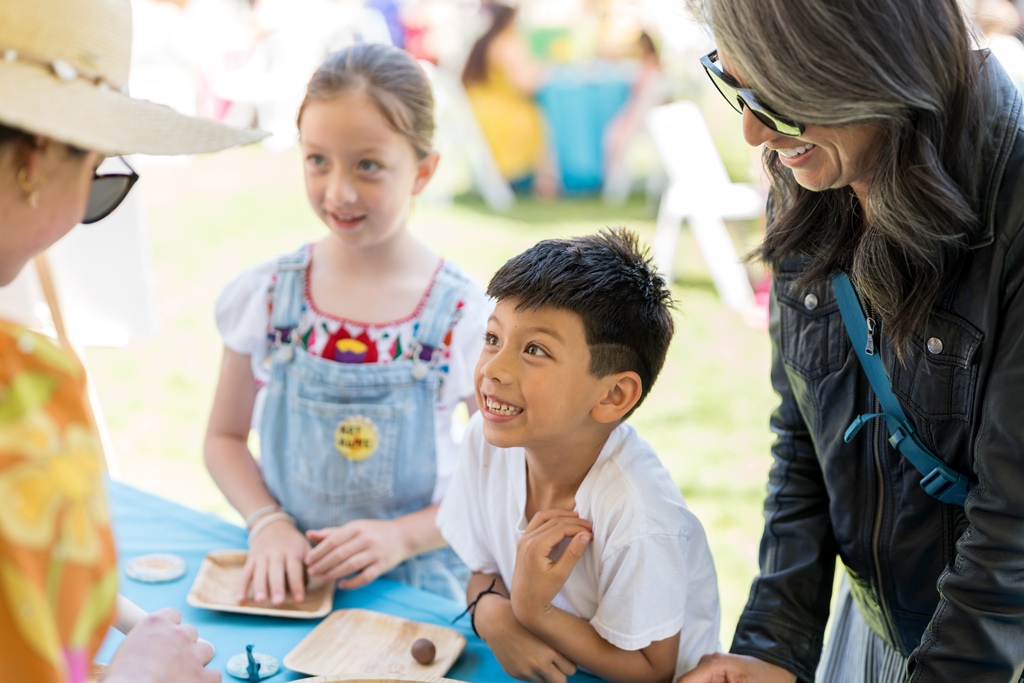 Children and woman smiling at the Art Alive Garden of Activities